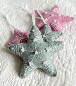 A handmade felt star hanging decoration. Medium size. Handmade in felt and hand sewn and embellished with glass beads and a hanging ribbon. Approximate size 9cm x 9cm (not including hanging ribbon) This is a decoration only, and is NOT a toy. Keep out of the reach of babies and small children due to the small parts.