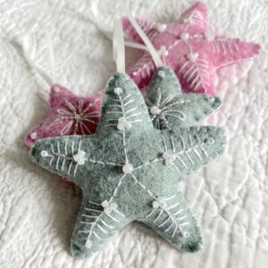 A handmade felt star hanging decoration. Medium size. Handmade in felt and hand sewn and embellished with glass beads and a hanging ribbon. Approximate size 9cm x 9cm (not including hanging ribbon) This is a decoration only, and is NOT a toy. Keep out of the reach of babies and small children due to the small parts.