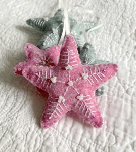 A handmade felt star hanging decoration. Medium size. Handmade in felt and hand sewn and embellished with glass beads and a hanging ribbon. Approximate size 9cm x 9cm (not including hanging ribbon) This is a decoration only, and is NOT a toy. Keep out of the reach of babies and small children due to the small parts.