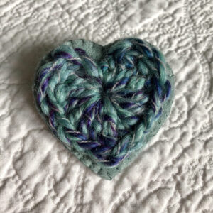 A crocheted heart on a hand stitched felt back with metal fixing brooch. Approximate size 6cm width x 6cm height.