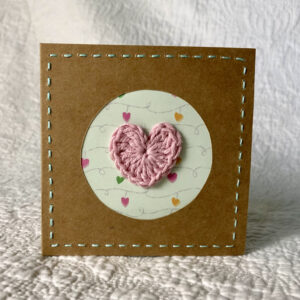 A single crocheted heart with hand stitched border on a small brown card (approximate size 10 x 10 cm)with blank white insert. Brown envelope included.
