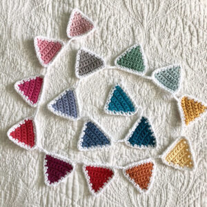 A rainbow of 16 individual coloured crocheted bunting flags. Handmade using 100% cotton yarn. Approximate length 125cm.