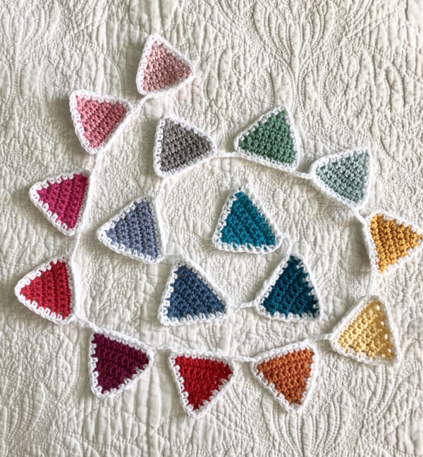 A rainbow of 16 individual coloured crocheted bunting flags. Handmade using 100% cotton yarn. Approximate length 125cm.