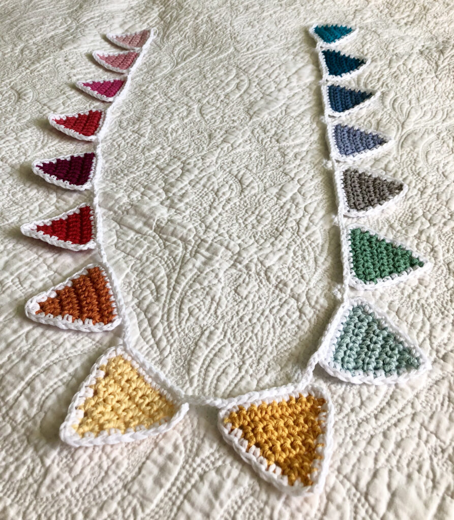 A rainbow of 16 individual coloured crocheted bunting flags. Handmade using 100% cotton yarn. Approximate length 125cm. 