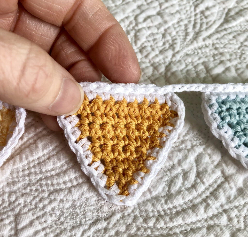 A rainbow of 16 individual coloured crocheted bunting flags. Handmade using 100% cotton yarn. Approximate length 125cm.