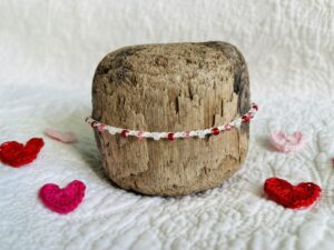 A handmade, crocheted, single stranded bracelet. Made using red, pink and cream pearlescent glass beads and 100% cream cotton with a fully adjustable sliding bead fastening.
No plastic has been used. This item is Vegan and Eco-friendly, reusable and fully recyclable.