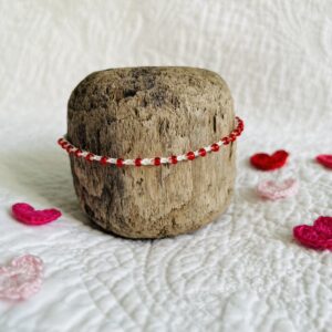 A handmade, crocheted, single stranded bracelet. Made using red glass beads and 100% cream cotton with a fully adjustable sliding bead fastening. No plastic has been used. This item is Vegan and Eco-friendly, reusable and fully recyclable.