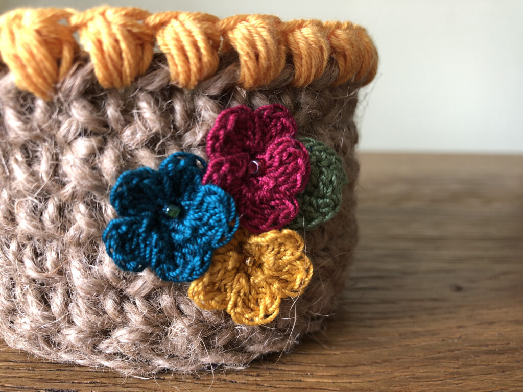 Handmade, crocheted 100% jute baskets. (Available in various sizes.) Decorated with 100% cotton crocheted flowers and leaves.