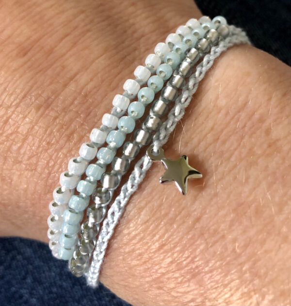 4 strand, fully adjustable bracelet with glass beads and silver metal coloured charm. Handmade using 100% cotton. Eco-friendly and fully recyclable.