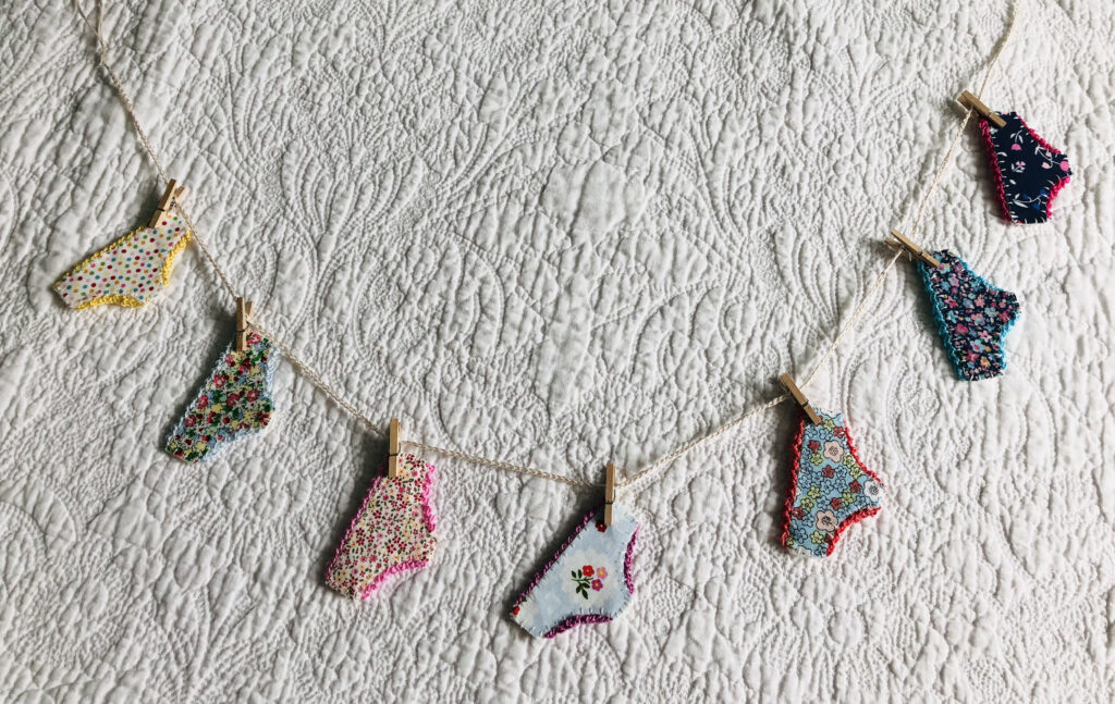 A handmade garland of positive pants. Made with fabric and felt and held with mini wooden pegs on a cotton line. Approximate length 90cm.