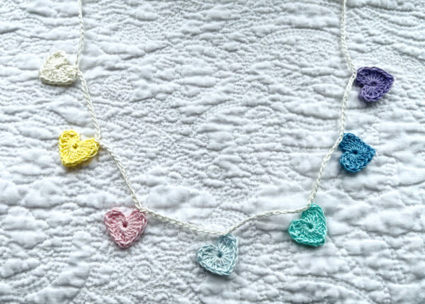 7 tiny crocheted hearts in a range of pastel colours. They are attached on a crocheted, natural cream cotton strand. Made in 100% cotton. Eco-friendly, vegan, recyclable, reusable. Total length approximately 53cm. Each heart measures approximately 2 x 2.5cm.