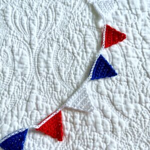 A garland of mini bunting triangles in Red, White and Blue on a white handing cord. Made using 100% Cotton. Eco and Vegan friendly. Reusable and fully recyclable. Approximate total length 90cm (but can stretch slightly). Each triangle measures approximately 3cm wide x 2.5cm height.