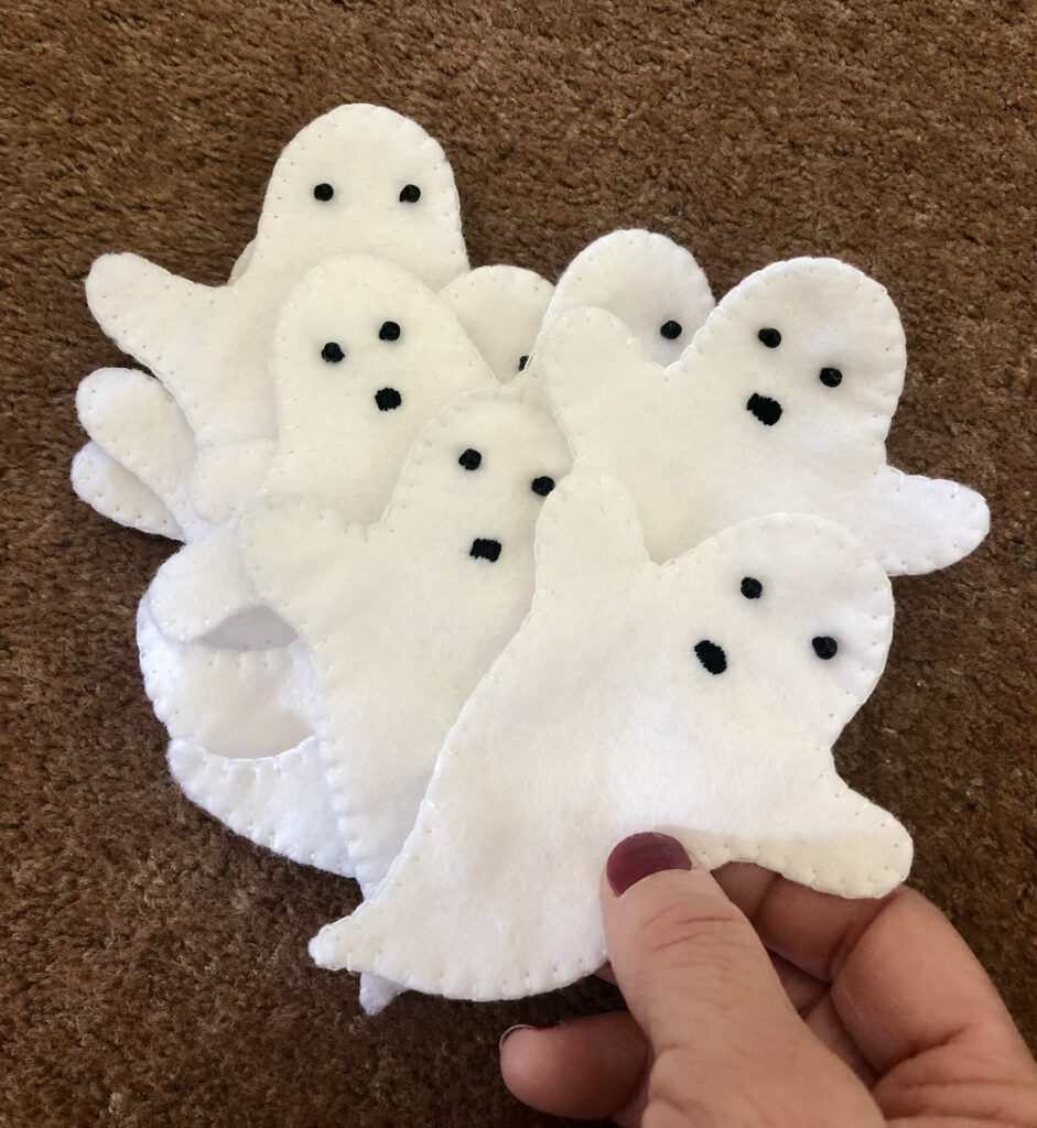 Hand stitched, white felt ghosts with hand embroidered facial details.