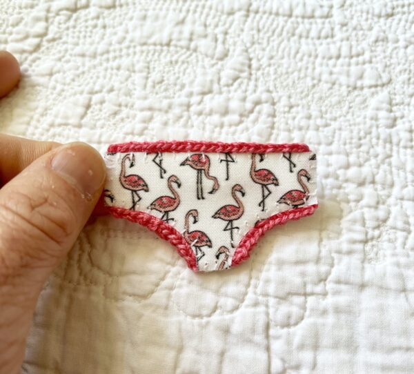 Handmade fabric and felt brooch with crocheted edging detail and a metal locking fastening. Approximate size 6cm Width x 4cm Height.