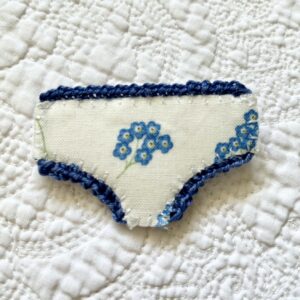 Handmade fabric and felt brooch with crocheted edging detail and a metal locking fastening. Approximate size 6cm Width x 4cm Height.