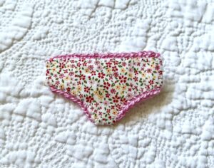 Handmade fabric and felt brooch with crocheted edging detail and a metal locking fastening. Approximate size 6cm Width x 4cm Height.