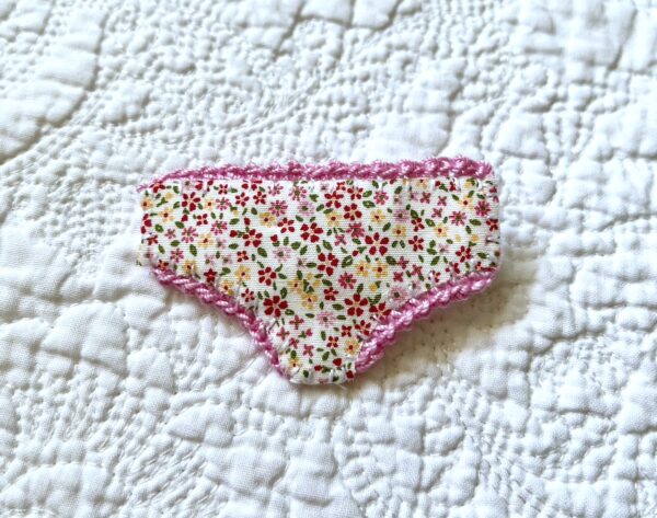 Handmade fabric and felt brooch with crocheted edging detail and a metal locking fastening. Approximate size 6cm Width x 4cm Height.