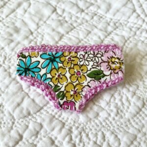 Handmade fabric and felt brooch with crocheted edging detail and a metal locking fastening. Approximate size 6cm Width x 4cm Height.