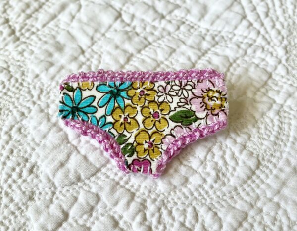 Handmade fabric and felt brooch with crocheted edging detail and a metal locking fastening. Approximate size 6cm Width x 4cm Height.