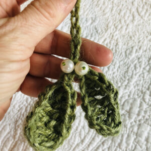 A hand made, crocheted, Mistletoe hanging decoration. made using 100% jute in green, with glass pearl and seed bead embellishments.