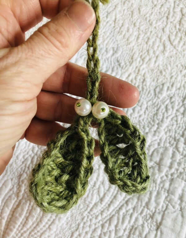 A hand made, crocheted, Mistletoe hanging decoration. made using 100% jute in green, with glass pearl and seed bead embellishments.