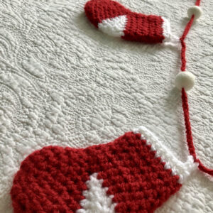 Garland of little Christmas stockings. 5 stockings with felt pom-pom details. Approximate length 125cm.